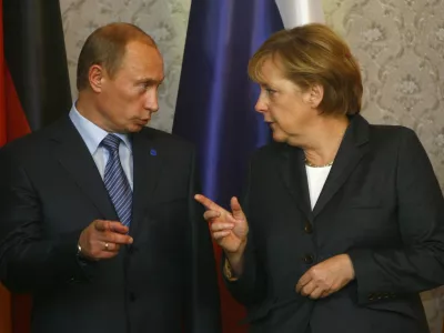 Russian President Vladimir Putin chats with German Chancellor Angela Merkel during the German-Russian governmental consultations St. Petersburg Dialogue in Wiesbaden October 15, 2007. REUTERS/Alex Grimm (GERMANY)