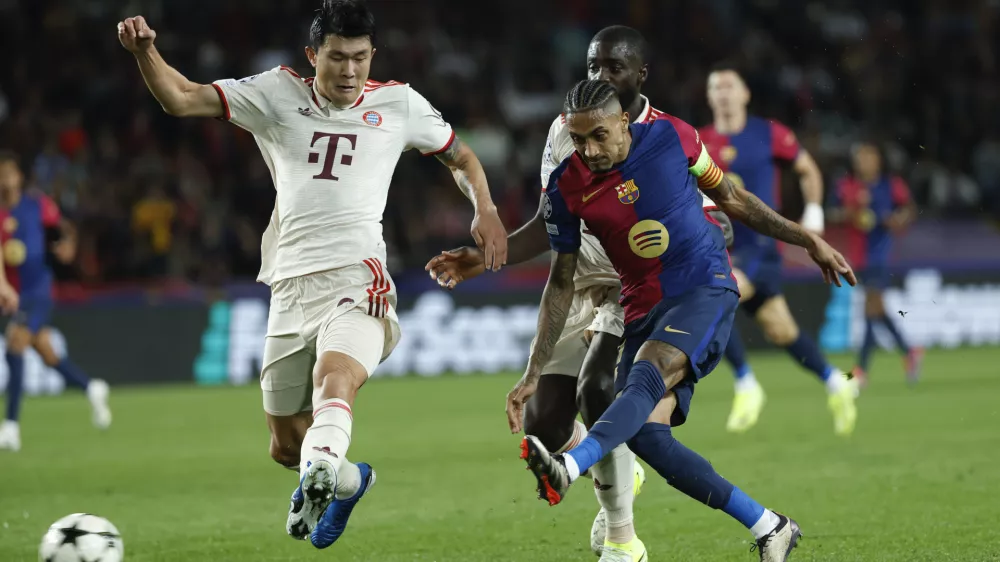 Barcelona's Raphinha, right, scores his sides forth goal as Bayern's Kim Min-jae, left, tries to stop him during a Champions League opening phase soccer match between Barcelona and Bayern Munich at the Lluis Companys Olympic Stadium in Barcelona, Spain, Wednesday, Oct. 23, 2024. (AP Photo/Joan Monfort)