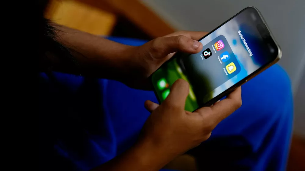 A high school student poses with her mobile showing her social media applications in Melbourne, Australia, November 28, 2024. REUTERS/Asanka Brendon Ratnayake