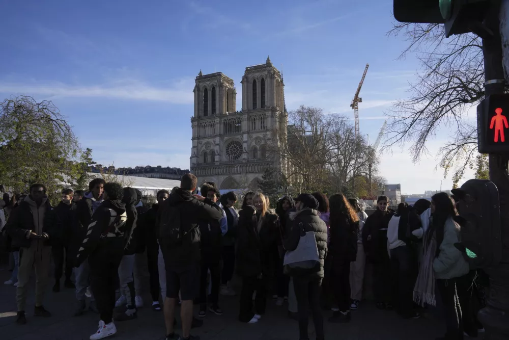 People gather as French President Emmanuel Macron visits the renovated Notre Dame Cathedral Friday, Nov. 29, 2024 in Paris. (AP Photo/Michel Euler)