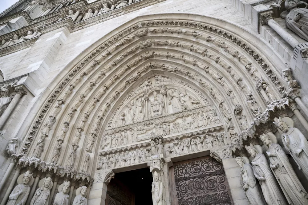 Part of the facade of Notre-Dame Cathedral is seen in Paris, Friday Nov., 29 2024 ahead of French President Emmanuel Macron's final visit to the construction site to see the restored interiors before the iconic monument's reopening for worship on Dec. 8. (Christophe Petit Tesson, Pool via AP)