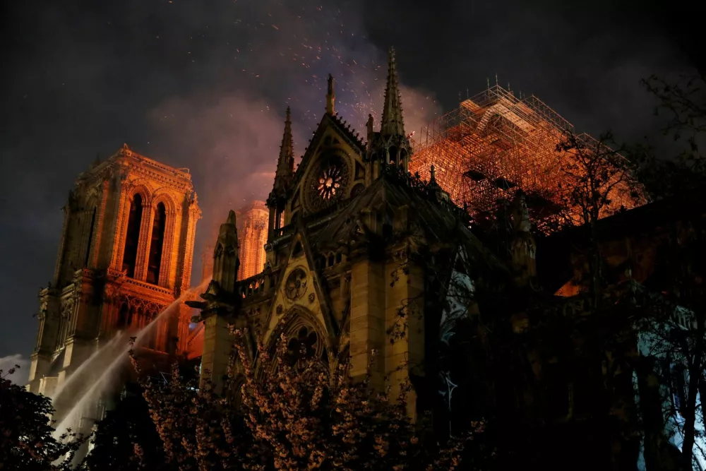 FILE PHOTO: Sparks fill the air as Paris Fire brigade members spray water to extinguish flames as the Notre Dame Cathedral burns in Paris, France, April 15, 2019.  REUTERS/Philippe Wojazer/File Photo