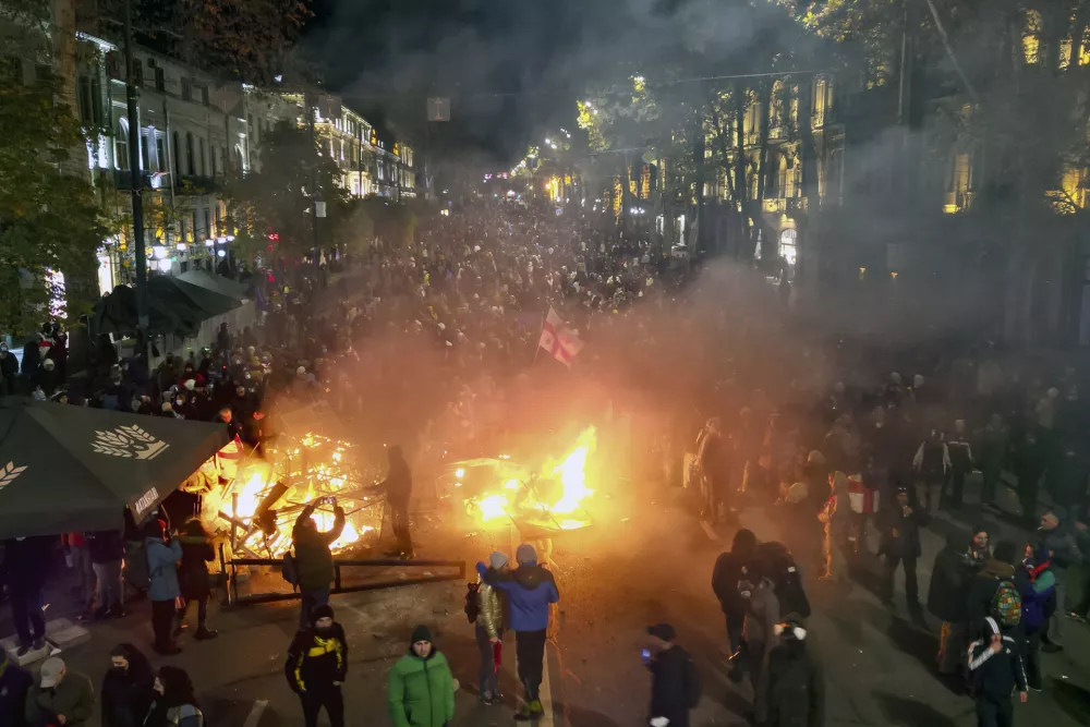 Protesters pour into the streets and put fire following Georgian Prime Minister Irakli Kobakhidze's announcement, rallying outside the parliament building in Tbilisi, Georgia, on Friday, Nov. 29, 2024. (AP Photo/Zurab Tsertsvadze)