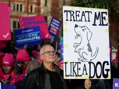 Graham Schafer holds a sign during a demonstration in support of assisted dying outside the British parliament as lawmakers debate the assisted dying law, in London, Britain, November 29, 2024. REUTERS/Mina Kim