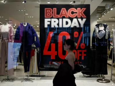 FILE PHOTO: A shopper walks past an advertisement for Black Friday sales displayed in a store window at Pentagon City in Arlington, Virginia, U.S., November 27, 2024. REUTERS/Benoit Tessier/File Photo