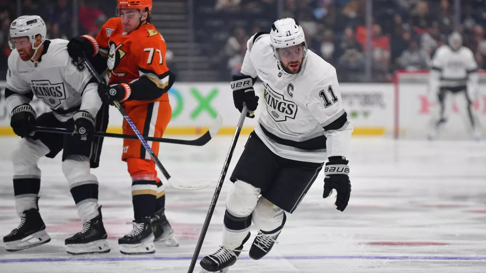 Nov 29, 2024; Anaheim, California, USA; Los Angeles Kings center Anze Kopitar (11) moves the puck against the Anaheim Ducks during the first period at Honda Center. Mandatory Credit: Gary A. Vasquez-Imagn Images