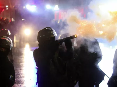 A law enforcement officer fires a tear gas canister as fireworks explode during a protest against the new government's decision to suspend the European Union accession talks and refuse budgetary grants until 2028, in Tbilisi, Georgia December 2, 2024. REUTERS/Irakli Gedenidze