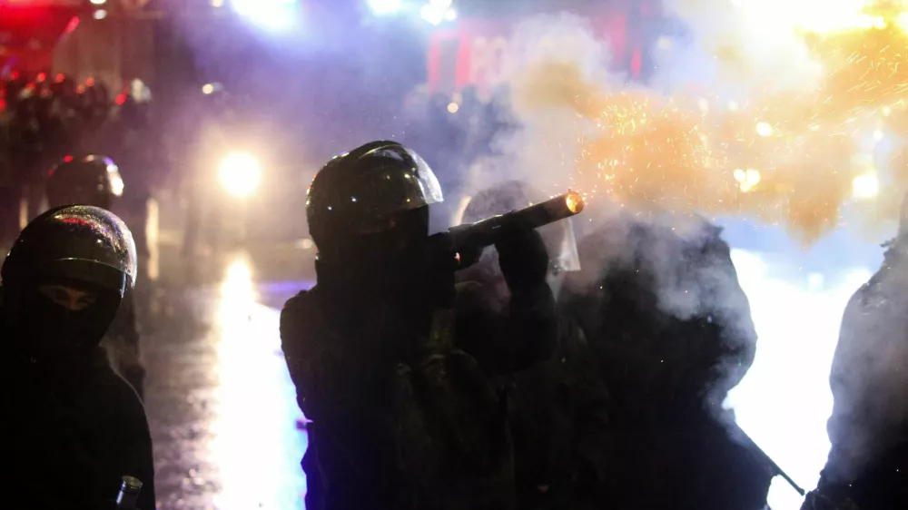 A law enforcement officer fires a tear gas canister as fireworks explode during a protest against the new government's decision to suspend the European Union accession talks and refuse budgetary grants until 2028, in Tbilisi, Georgia December 2, 2024. REUTERS/Irakli Gedenidze