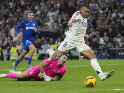 Real Madrid's Kylian Mbappe kicks the ball in an attempt to score during the Spanish La Liga soccer match between Real Madrid and Getafe at the Santiago Bernabeu Stadium in Madrid, Spain, Sunday, Dec. 1, 2024. (AP Photo/Bernat Armangue)