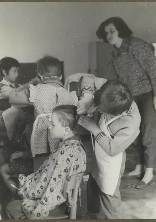 Vzgojno-varstveni zavod Ane Ziherl, otroci pri "frizerjih" v frizerskem kotičku leta 1961. Hrani Vrtec Ledina. 