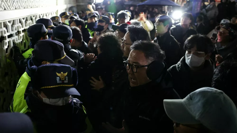 People react as police close the gate of the National Assembly, after South Korean President Yoon Suk Yeol declared martial law, in Seoul, South Korea, December 4, 2024. REUTERS/Kim Hong-Ji