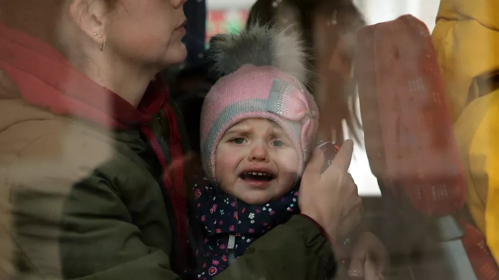 A Ukrainian refugees child reacts as he boards a bus after arriving at Hendaye train station, southwestern France, Wednesday, March 9, 2022. About 200 Ukrainian refugees are arriving in the French Atlantic coast town of Hendaye, where local authorities are greeting them in the train station and offering them temporary lodging. They are among 2 million people, mostly women and children, who have fled fighting in Ukraine since Russia's invasion two weeks ago and are seeking refuge around Europe.(AP Photo/Bob Edme)