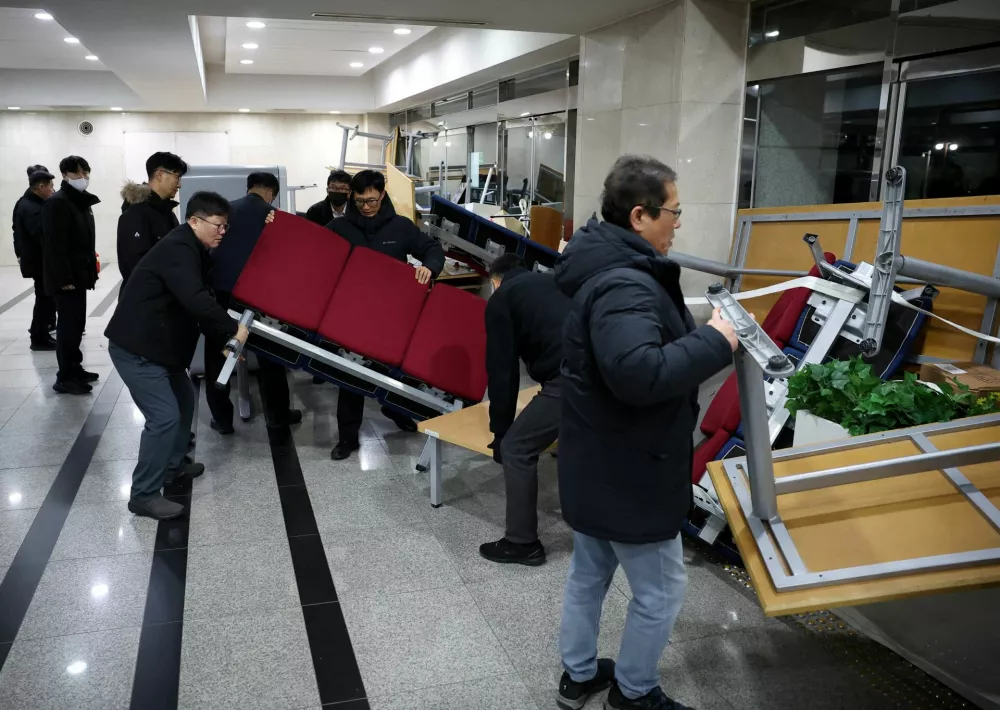 Officials remove the furniture barricades from the doors of the National Assembly building, after South Korean President Yoon Suk Yeol declared martial law, in Seoul, South Korea, December 4, 2024. REUTERS/Kim Hong-Ji   TPX IMAGES OF THE DAY