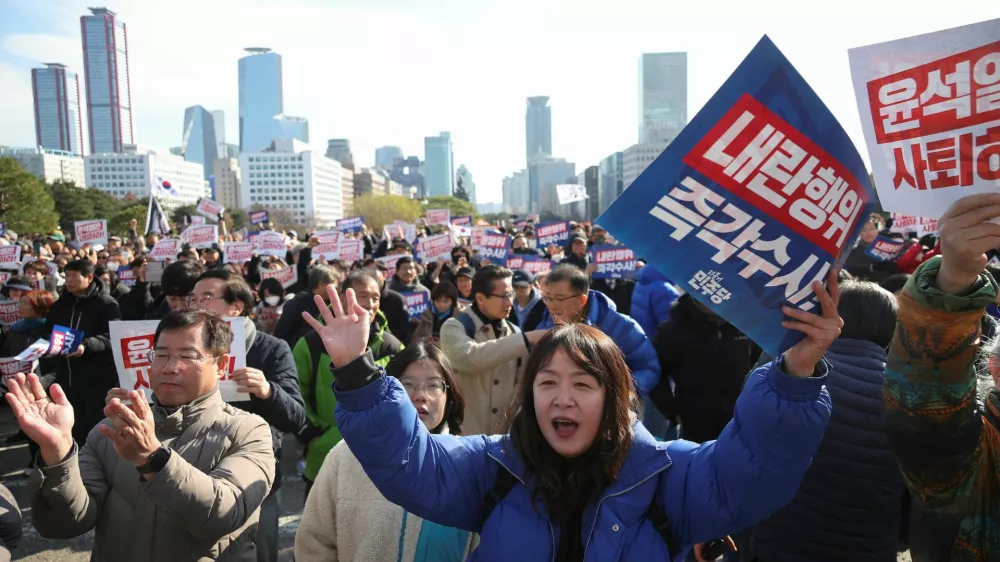 People hold placards that read "Step down President Yoon Suk Yeol" and "Investigate his act of rebellion immediately", at a rally to condemn South Korean President's surprise declarations of the martial law last night and to call for his resignation, at the national assembly in Seoul, South Korea, December 4, 2024. REUTERS/Kim Hong-Ji