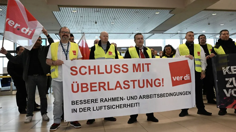 Aviation security workers of Germany's Verdi union gather at Cologne-Bonn airport during a strike in Cologne, Germany, April 20, 2023. The placard reads "end pressure of work". REUTERS/Jana Rodenbusch