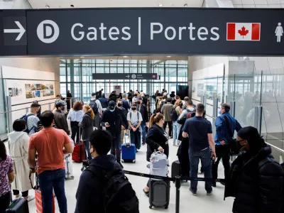 FILE PHOTO: Travellers crowd the security queue in the departures lounge at the start of the Victoria Day holiday long weekend at Toronto Pearson International Airport in Mississauga, Ontario, Canada, May 20, 2022. REUTERS/Cole Burston/File Photo