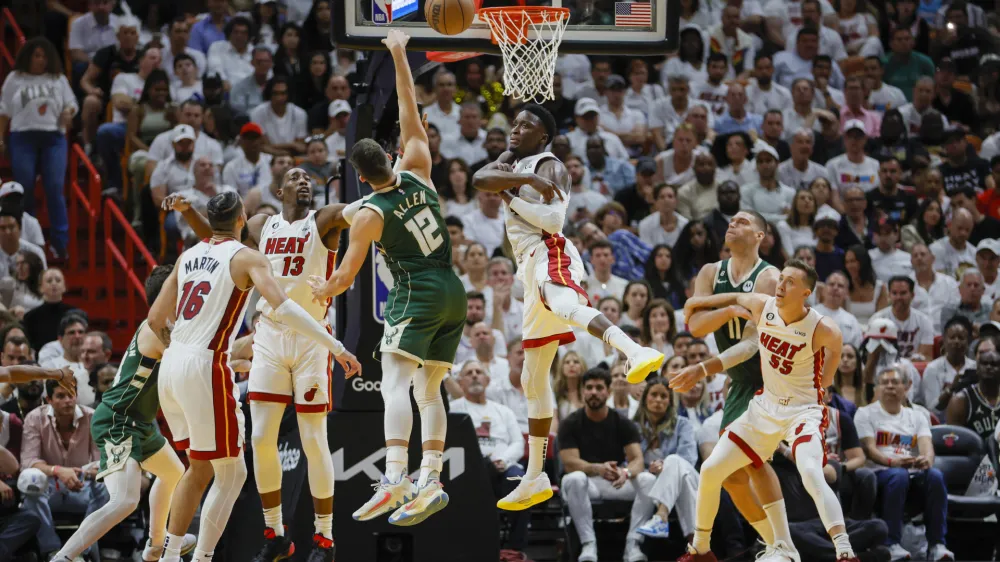 Apr 22, 2023; Miami, Florida, USA; Miami Heat guard Victor Oladipo (4) blocks the shot of Milwaukee Bucks guard Grayson Allen (12) in the fourth quarter during game three of the 2023 NBA Playoffs at Kaseya Center. Mandatory Credit: Sam Navarro-USA TODAY Sports