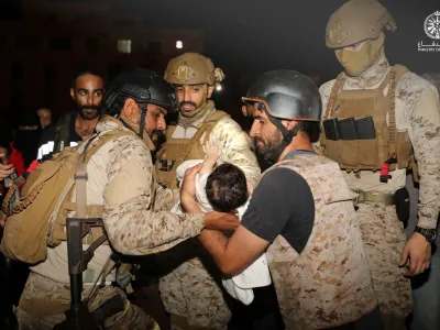 Saudi Royal Navy officers assist a child onboard their navy ship as they evacuate Saudis and other nationals are through Saudi Navy Ship from Sudan to escape the conflicts, Port Sudan, Sudan, April 22, 2023. Saudi Ministry of Defense/Handout via REUTERS ATTENTION EDITORS - THIS PICTURE WAS PROVIDED BY A THIRD PARTY