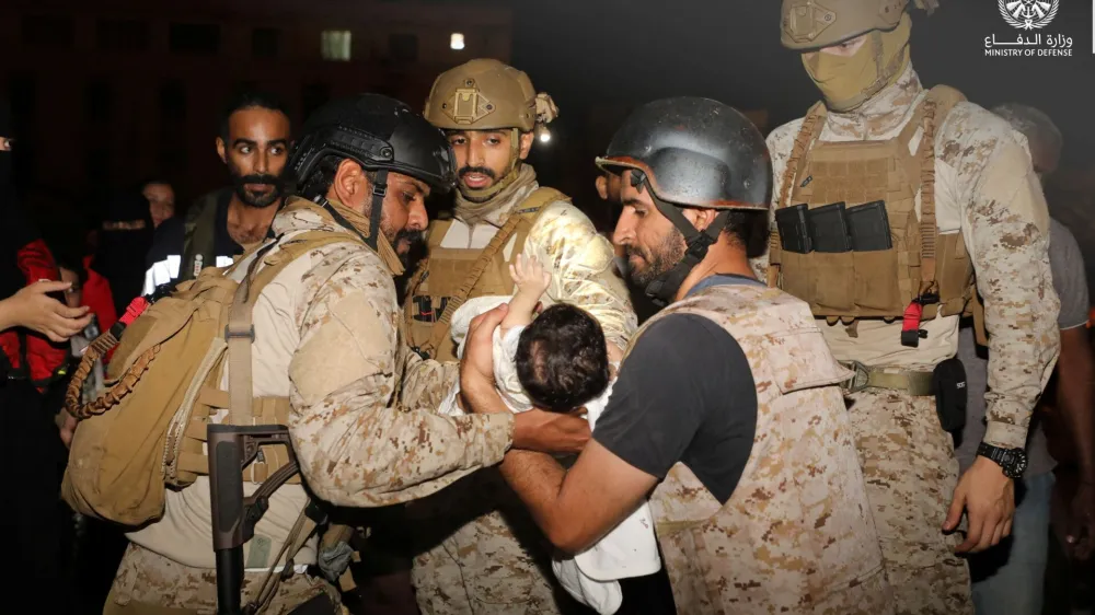 Saudi Royal Navy officers assist a child onboard their navy ship as they evacuate Saudis and other nationals are through Saudi Navy Ship from Sudan to escape the conflicts, Port Sudan, Sudan, April 22, 2023. Saudi Ministry of Defense/Handout via REUTERS ATTENTION EDITORS - THIS PICTURE WAS PROVIDED BY A THIRD PARTY