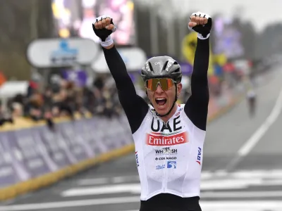 Slovenia's Tadej Pogacar of the UAE Team Emirates celebrates as he crosses the finish line to win the Tour of Flanders in Oudenaarde, Belgium on Sunday, April 2, 2023. (AP Photo/Geert Vanden Wijngaert)