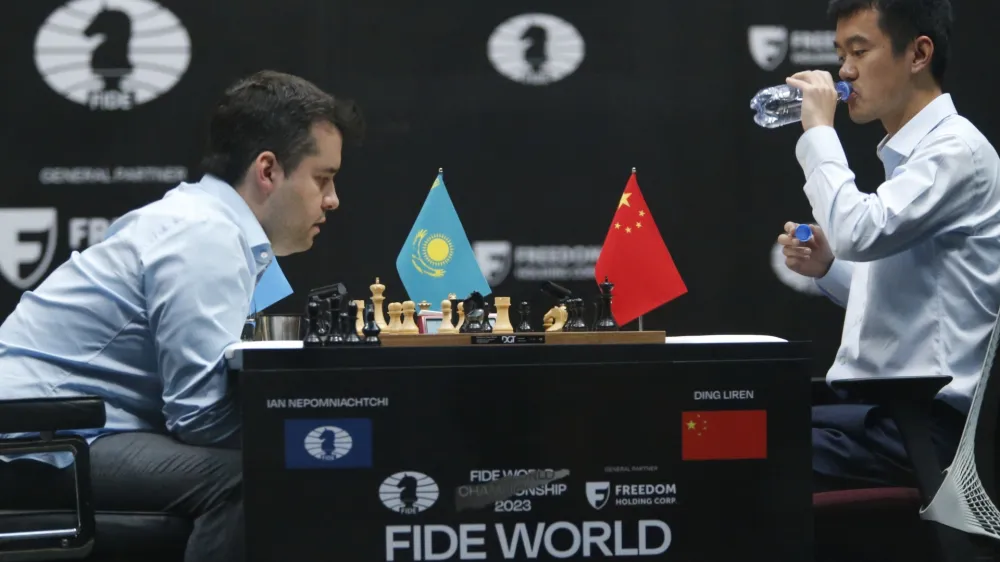 China's Ding Liren, right, drinks water as Russia's Ian Nepomniachtchi plays during their tiebreaker of FIDE World Chess Championship in Astana, Kazakhstan, Sunday, April 30, 2023. (AP Photo/Stanislav Filippov)