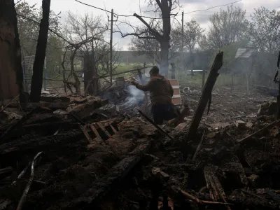 Tatiana Makohon, 56-year-old, carries items from a house of her friend destroyed by a Russian drone strike in the village of Malotaranivka, amid Russia's attack on Ukraine, in Donetsk region, Ukraine April 29, 2023. REUTERS/Sofiia Gatilova