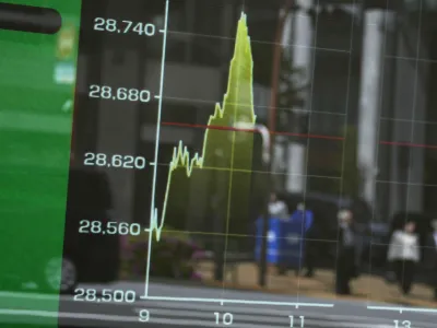 An electronic stock board shows the morning movement of Japan's Nikkei 225 index with passersby seen reflected on it, Friday, April 21, 2023 in Tokyo. Shares are weaker in Asia after benchmarks dipped on Wall Street following mixed earnings reports from big companies and more signals the U.S. economy may be slowing. (AP Photo/Shuji Kajiyama)