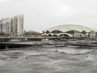 Dokler lastnica nasedlega nakupovalnega centra, družba Rastoder, ne dokonča svojega dela kompleksa, tudi ljubljanska občina ne more do konca urediti javnih zelenih površin in še enega nogometnega igrišča v okolici športnega centra Stožice. 