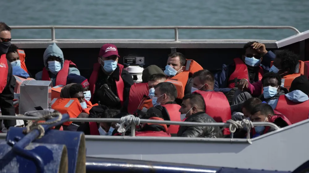 People thought to be migrants who undertook the crossing from France in small boats and were picked up in the Channel, wait to be disembarked from a British border force vessel, in Dover, south east England, Friday, June 17, 2022. The British government vowed Wednesday to organize more flights to deport asylum-seekers from around the world to Rwanda, after a last-minute court judgment grounded the first plane due to take off under the contentious policy. (AP Photo/Matt Dunham)