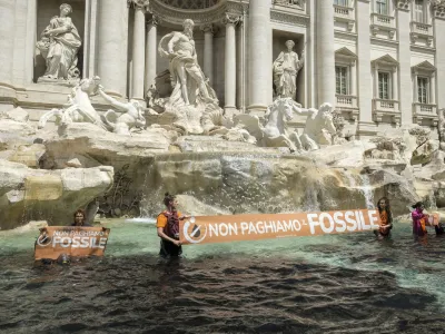 Last Generation environmentalists show a banner against the use of fossil fuels in the Trevi Fountain in Rome, Sunday, May 21, 2023. (Mauro Scrobogna/LaPresse via AP)