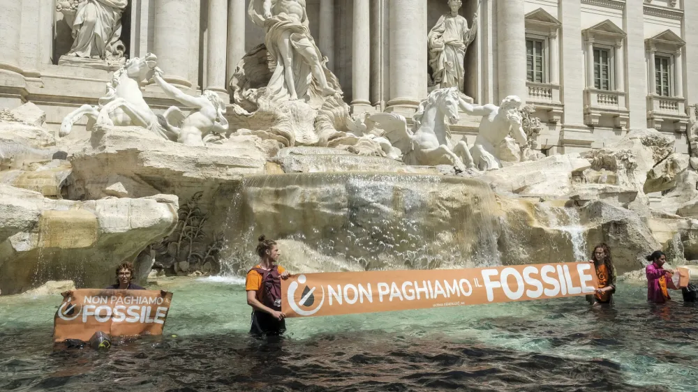 Last Generation environmentalists show a banner against the use of fossil fuels in the Trevi Fountain in Rome, Sunday, May 21, 2023. (Mauro Scrobogna/LaPresse via AP)