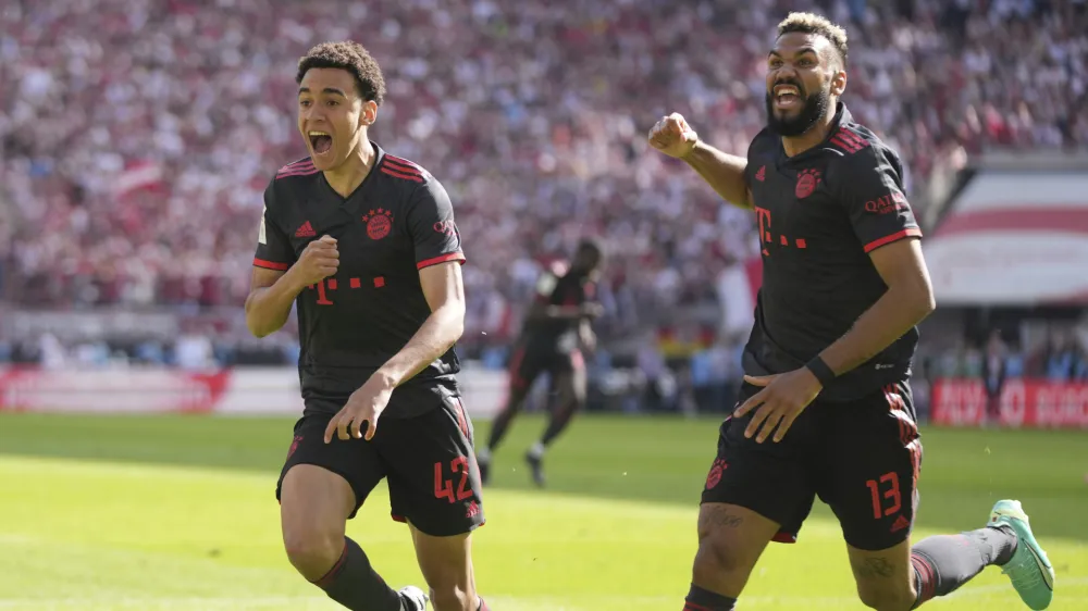 Bayern's Jamal Musiala, left, celebrates with Bayern's Eric Maxim Choupo-Moting after scoring his side's second goal during the German Bundesliga soccer match between 1.FC Cologne and FC Bayern Munich in Cologne, Germany, Saturday, May 27, 2023. (AP Photo/Matthias Schrader)