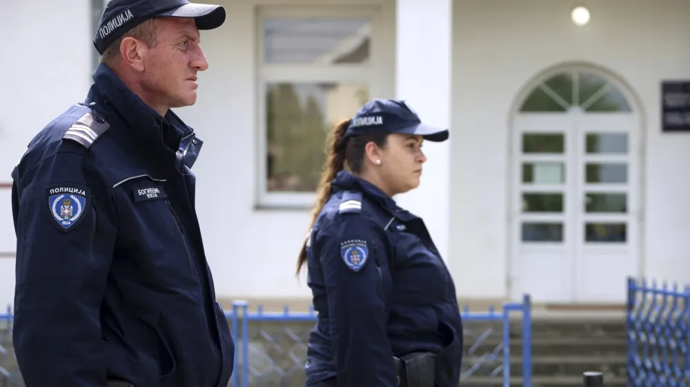 Police officers stand guard next to the schoolyard in the village of Dubona, some 50 kilometers (30 miles) south of Belgrade, Serbia, Friday, May 5, 2023. A shooter killed multiple people and wounded more in a drive-by attack late Thursday in Serbia's second such mass killing in two days, state television reported. (AP Photo/Armin Durgut)