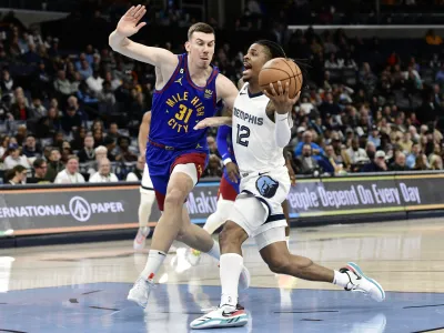 Memphis Grizzlies guard Ja Morant (12) drives against Denver Nuggets forward Vlatko Cancar (31) in the second half of an NBA basketball game Saturday, Feb. 25, 2023, in Memphis, Tenn. (AP Photo/Brandon Dill)