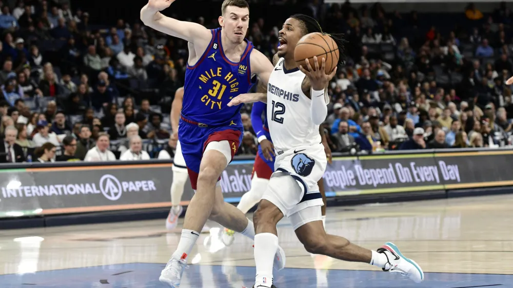 Memphis Grizzlies guard Ja Morant (12) drives against Denver Nuggets forward Vlatko Cancar (31) in the second half of an NBA basketball game Saturday, Feb. 25, 2023, in Memphis, Tenn. (AP Photo/Brandon Dill)