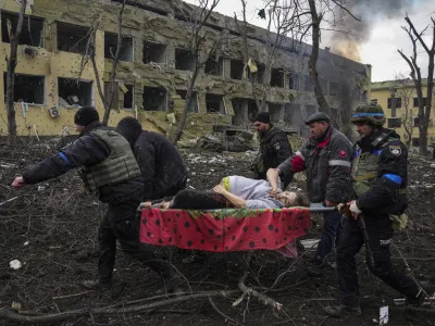 FILE - Ukrainian emergency employees and police officers evacuate injured pregnant woman Iryna Kalinina, 32, from a maternity hospital that was damaged by a Russian airstrike in Mariupol, Ukraine, March 9, 2022. The award-winning film "20 Days in Mariupol" got its premiere in Ukraine on Saturday, June 3, 2023, attended by some Ukrainian medics and security officials who got their first look at the jarring documentary on how Russian forces bombed and blasted their way into the southeastern port city last year. (AP Photo/Evgeniy Maloletka, File)