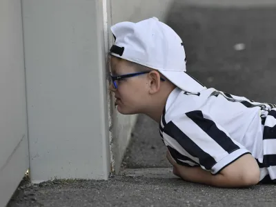 Soccer Football - Europa League - Juventus Training - Juventus Training Centre, Turin, Italy - April 19, 2023 A young Juventus fan watches the training from outside REUTERS/Massimo Pinca