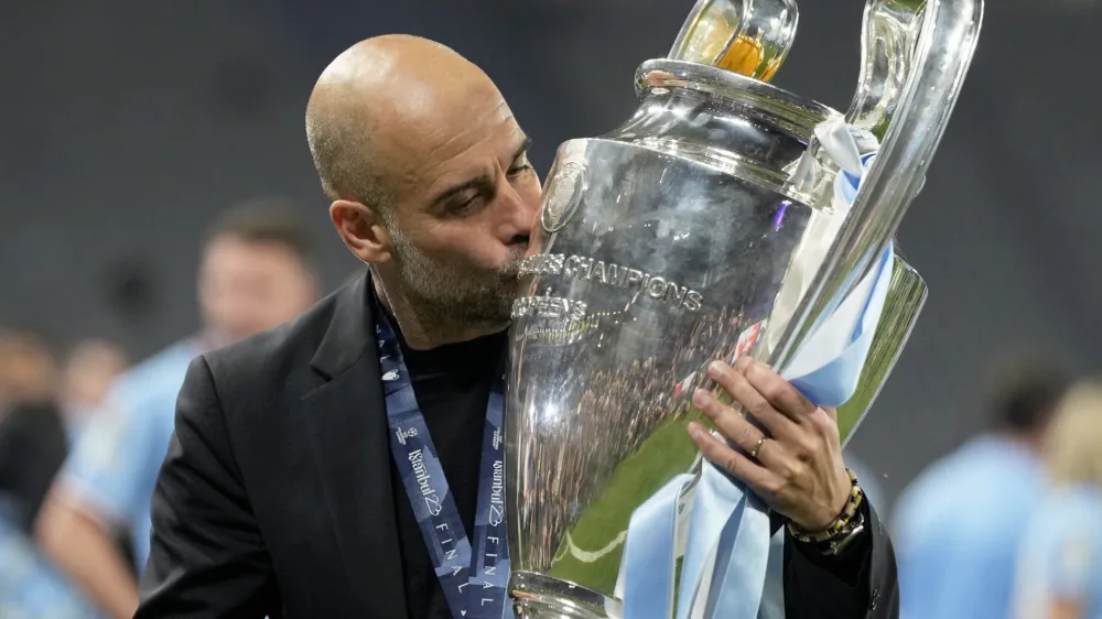 Manchester City's head coach Pep Guardiola kisses the trophy after winning the Champions League final soccer match between Manchester City and Inter Milan at the Ataturk Olympic Stadium in Istanbul, Turkey, Sunday, June 11, 2023. Manchester City won 1-0. (AP Photo/Francisco Seco)