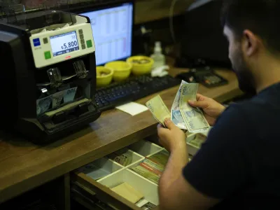 A worker counts Turkish lira banknotes in an exchange currency shop in Istanbul, Turkey, Tuesday, June 20, 2023. Turkey's central bank delivered a large interest rate hike Thursday, signaling a shift toward more conventional economic policies to counter sky-high inflation following criticism that President Recep Tayyip Erdogan's approach has made a cost-of-living crisis worse. (AP Photo/Francisco Seco)