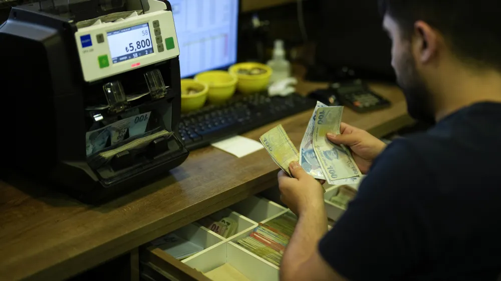 A worker counts Turkish lira banknotes in an exchange currency shop in Istanbul, Turkey, Tuesday, June 20, 2023. Turkey's central bank delivered a large interest rate hike Thursday, signaling a shift toward more conventional economic policies to counter sky-high inflation following criticism that President Recep Tayyip Erdogan's approach has made a cost-of-living crisis worse. (AP Photo/Francisco Seco)