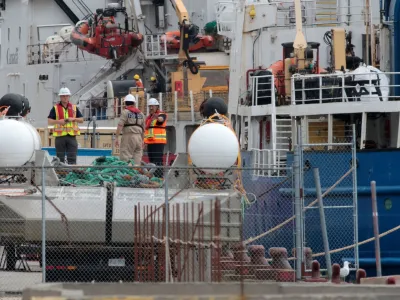 People inspect the Polar Prince ship and the deployment barge, used with the Titan submersible that imploded while carrying five people to explore the wreck of the sunken Titanic, as the Transportation Safety Board of Canada begins its investigation into the loss of the submersible from OceanGate Expeditions, at St. John's harbour, Newfoundland, Canada June 25, 2023. REUTERS/David Hiscock NO RESALES. NO ARCHIVES