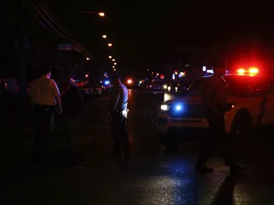 Philadelphia police stand at the intersection of 56th Street and Kingsessing Avenue after multiple people were shot in Southwest Philadelphia, late Monday, July 3, 2023. (Yong Kim/The Philadelphia Inquirer via AP)