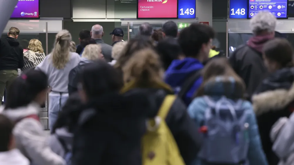 Passengers wait to be checked at an airport in Duesseldorf, Germany Thursday, April 20, 2023. A German labor union is calling for railway workers to stage an eight-hour strike on Friday to back calls for an inflation-busting pay raise. Walkouts are also scheduled at three airports this week in a parallel pay dispute. (David Young/dpa via AP)