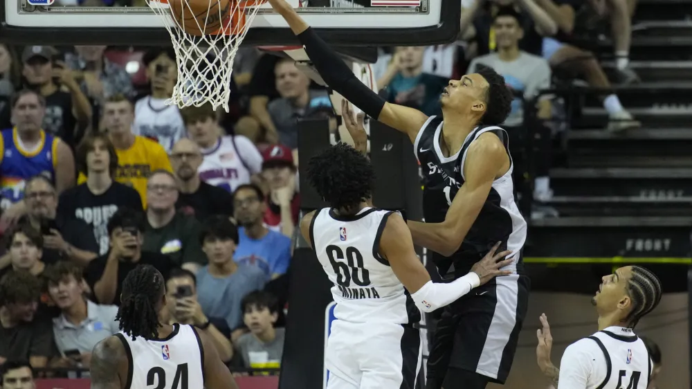 San Antonio Spurs' Victor Wembanyama dunks over Portland Trail Blazers' Justin Minaya during the first half of an NBA summer league basketball game Sunday, July 9, 2023, in Las Vegas. (AP Photo/John Locher)