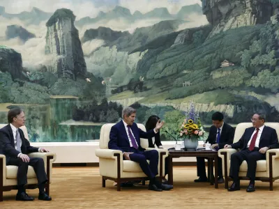 U.S. Special Presidential Envoy for Climate John Kerry, center, attends a meeting with Chinese Premier Li Qiang, right, at the Great Hall of the People in Beijing Tuesday, July 18, 2023. (Florence Lo/Pool Photo via AP)