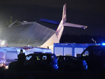 The tail of a Cessna 208 plane sticks out of a hangar after it crashed there in bad weather killing several people and injuring others, at a sky-diving centre in Chrcynno, central Poland, on Monday, July 17, 2023. (AP Photo/Czarek Sokolowski)