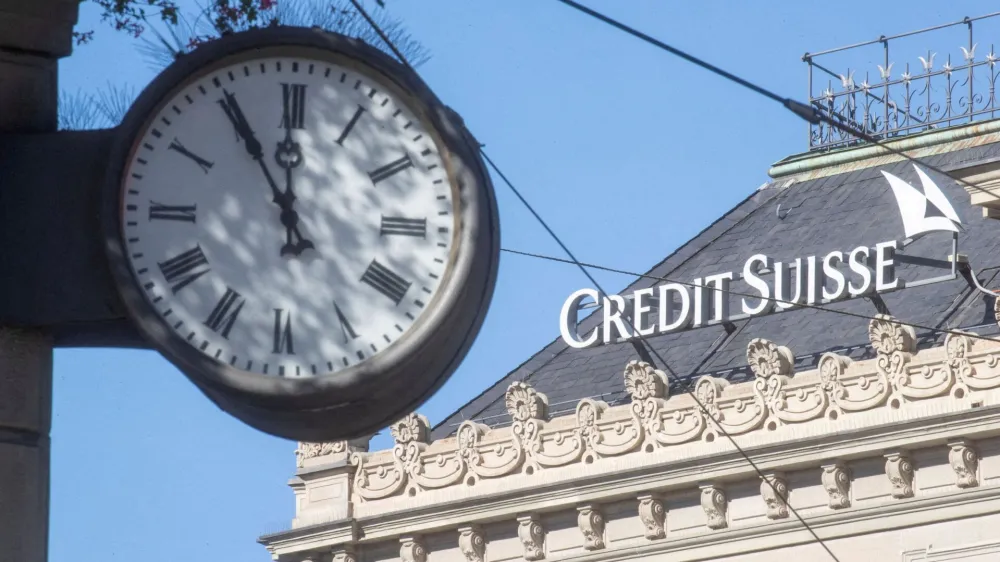 FILE PHOTO: A clock is seen near the logo of Swiss bank Credit Suisse at the Paradeplatz square in Zurich, Switzerland October 5, 2022. REUTERS/Arnd Wiegmann/File Photo