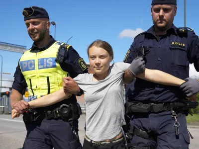 Climate activist Greta Thunberg is detained by police during an action for blocking the entrance to an oil facility in Malmo, Sweden, Monday, July 24, 2023. The protest took place just a few hours after Thunberg was fined for disobeying police during a similar protest last month at the same terminal. (AP Photo/Pavel Golovkin)