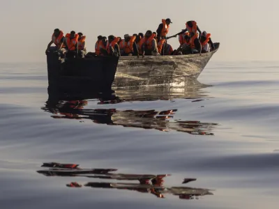 FILE - Migrants with life jackets provided by volunteers of the Ocean Viking, a migrant search and rescue ship run by NGOs SOS Mediterranee and the International Federation of Red Cross (IFCR), sail in a wooden boat as they are being rescued some 26 nautical miles south of the Italian Lampedusa island in the Mediterranean sea, on Aug. 27, 2022. The U.N. human rights chief is appealing to governments to do more to help migrants and asylum-seekers after a "steep increase" in the numbers making risky attempts to cross the central Mediterranean to Europe. (AP Photo/Jeremias Gonzalez, File)