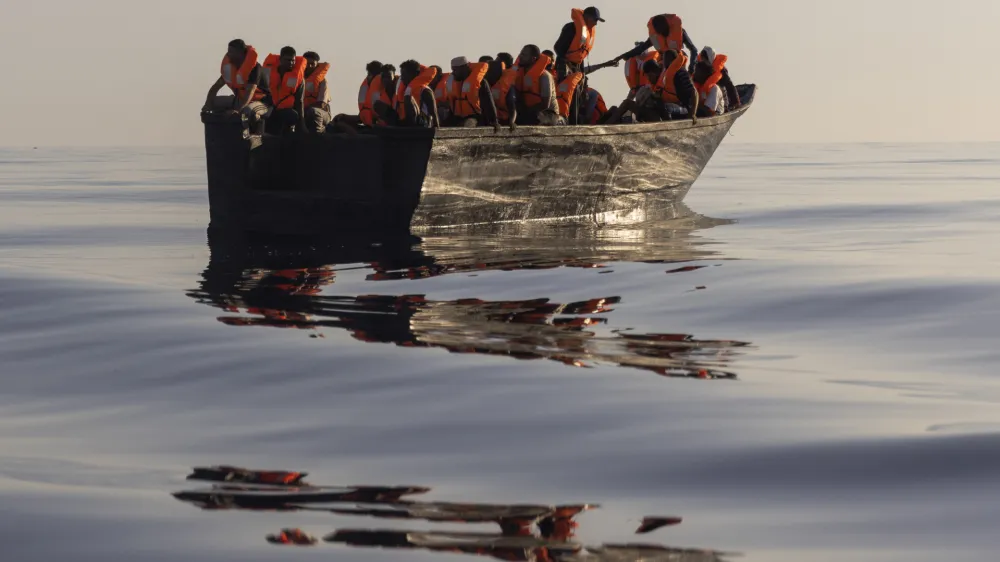 FILE - Migrants with life jackets provided by volunteers of the Ocean Viking, a migrant search and rescue ship run by NGOs SOS Mediterranee and the International Federation of Red Cross (IFCR), sail in a wooden boat as they are being rescued some 26 nautical miles south of the Italian Lampedusa island in the Mediterranean sea, on Aug. 27, 2022. The U.N. human rights chief is appealing to governments to do more to help migrants and asylum-seekers after a "steep increase" in the numbers making risky attempts to cross the central Mediterranean to Europe. (AP Photo/Jeremias Gonzalez, File)